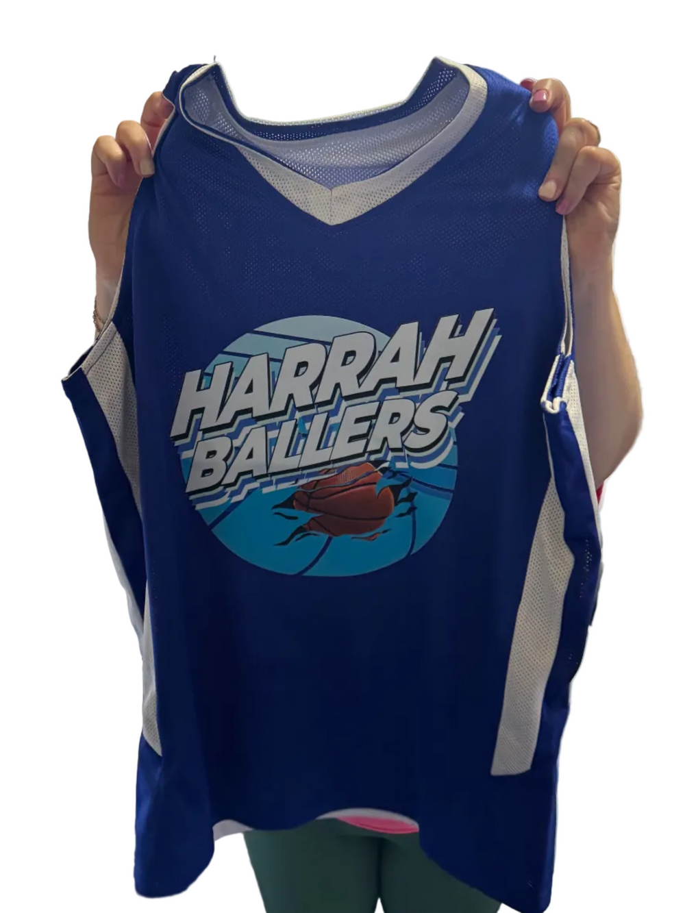 Person holding a blue tank top with 'Harrah Ballers' print in an indoor setting.